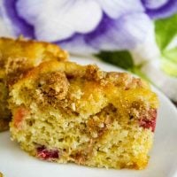 A Rhubarb Muffin with Crumb Topping cut in half on a white plate